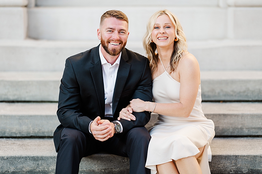 couple sitting on steps at downtown engagement