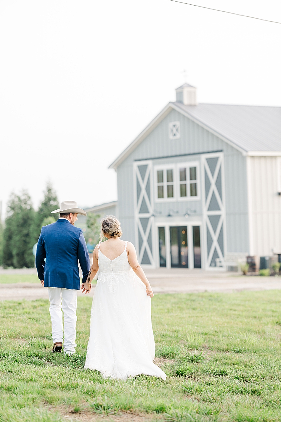 Walking towards the barn at wedding by Amanda May Photos