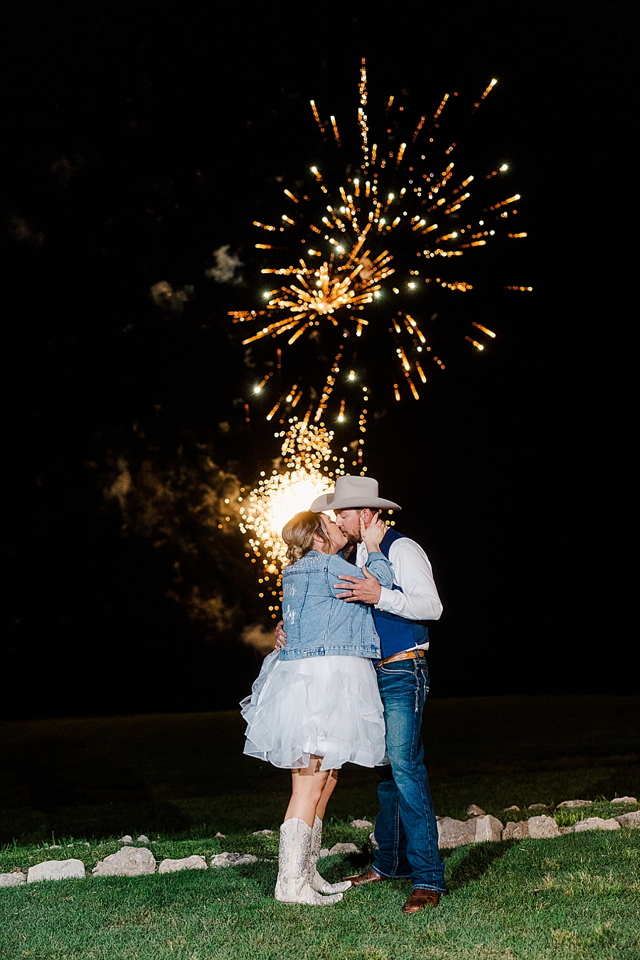 Bride and groom kiss under fireworks at wedding by Amanda May Photos