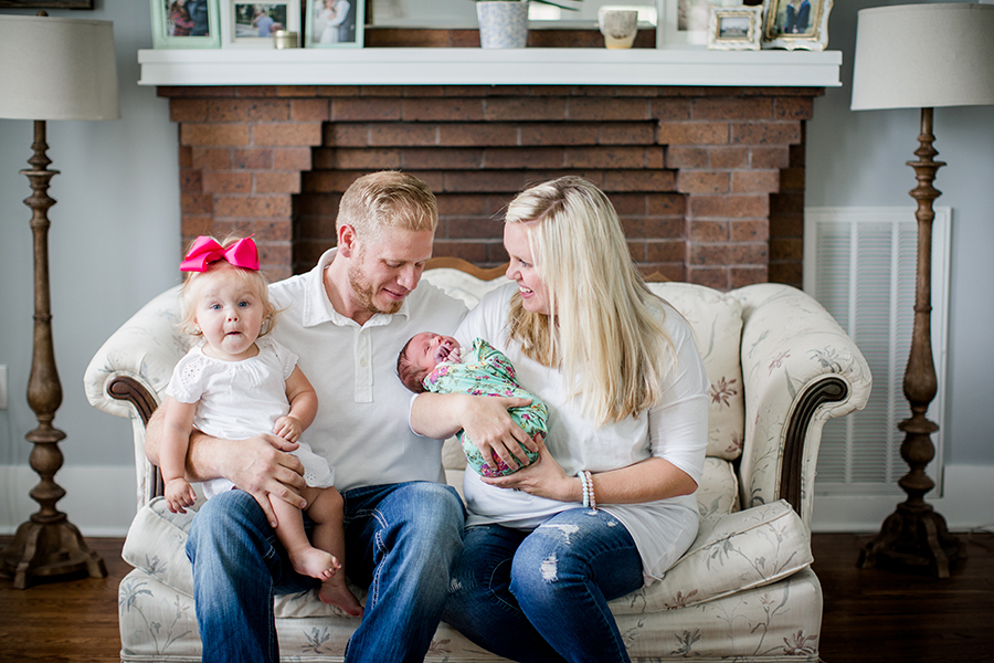 Family of four sitting on couch at this newborn session by Knoxville Wedding Photographer, Amanda May Photos.