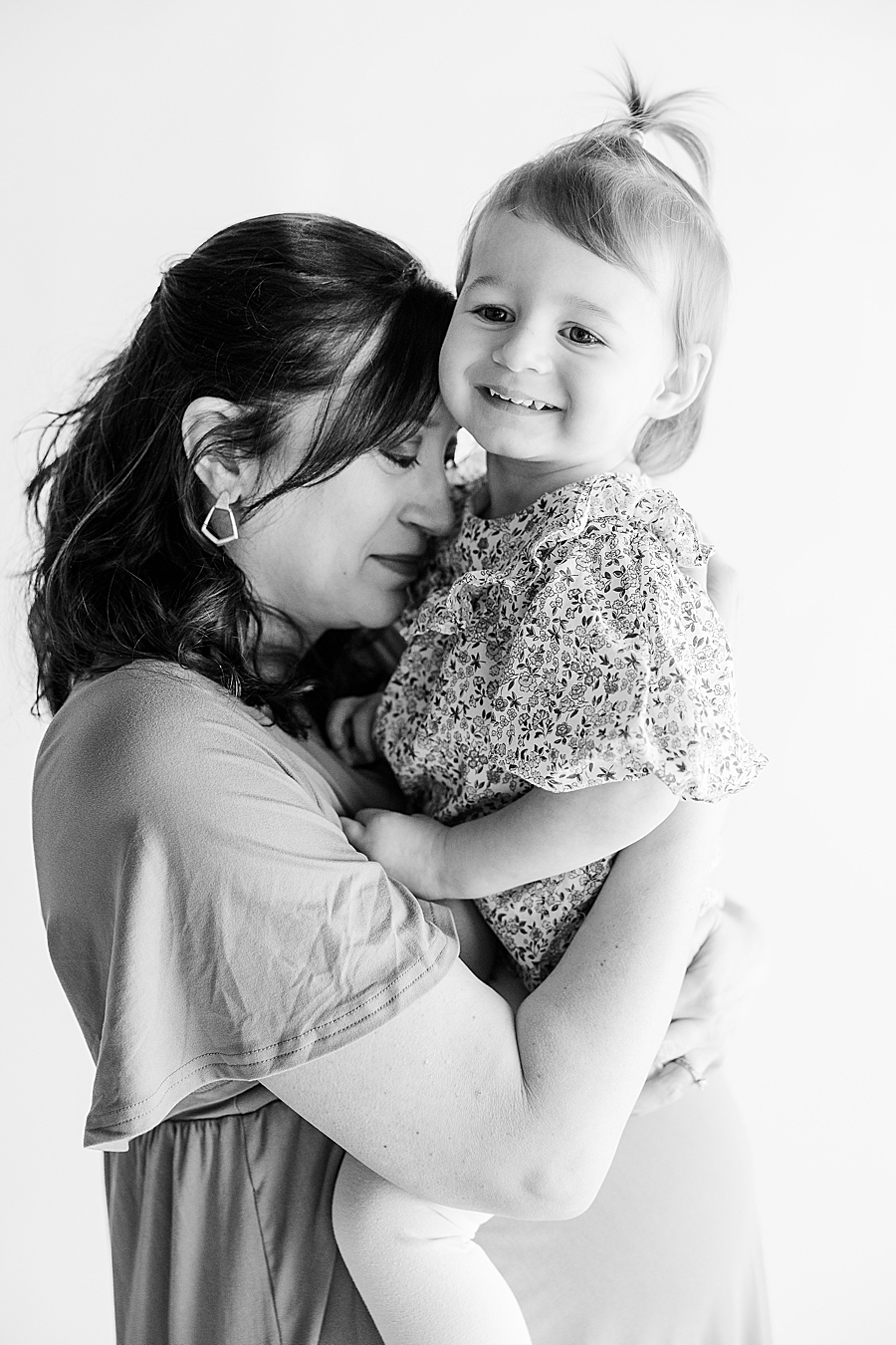 mom holding daughter at highlight studio maternity session