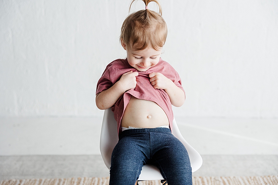 little girl showing belly button