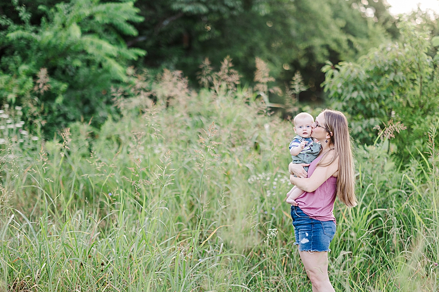 mother holding son in tall grass