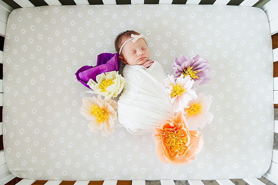 newborn surrounded by flowers