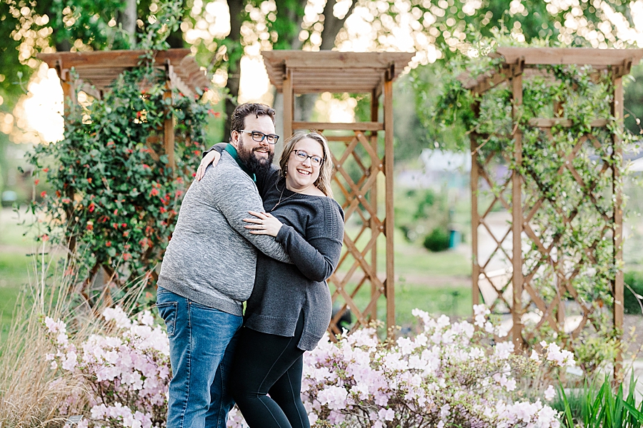 Hugging by the flowers at engagement session by Amanda May Photos