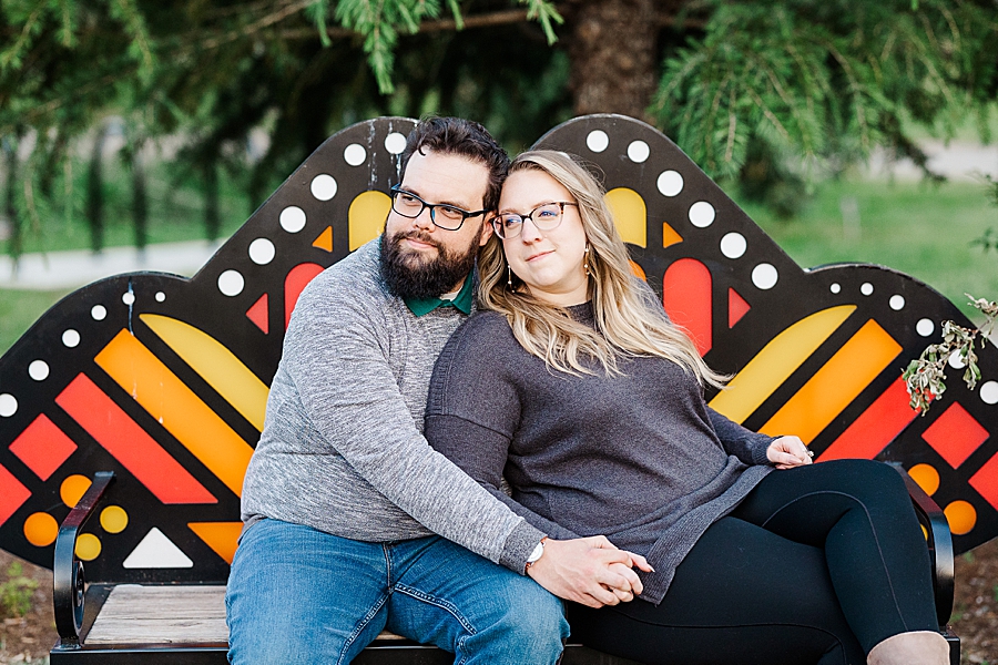 Snuggling on a bench at engagement session by Amanda May Photos