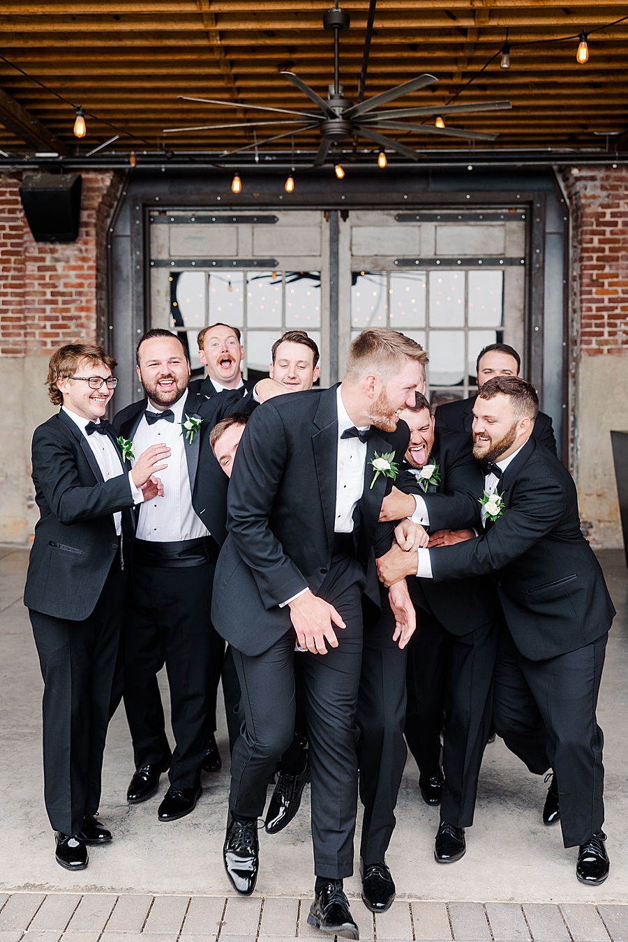 Groomsmen tackle groom at Mill & Mine Wedding by Amanda May Photos
