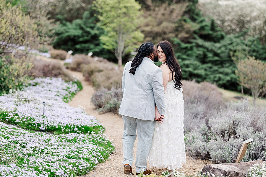 Kissing her cheek at Garden Engagement Session by Amanda May Photos