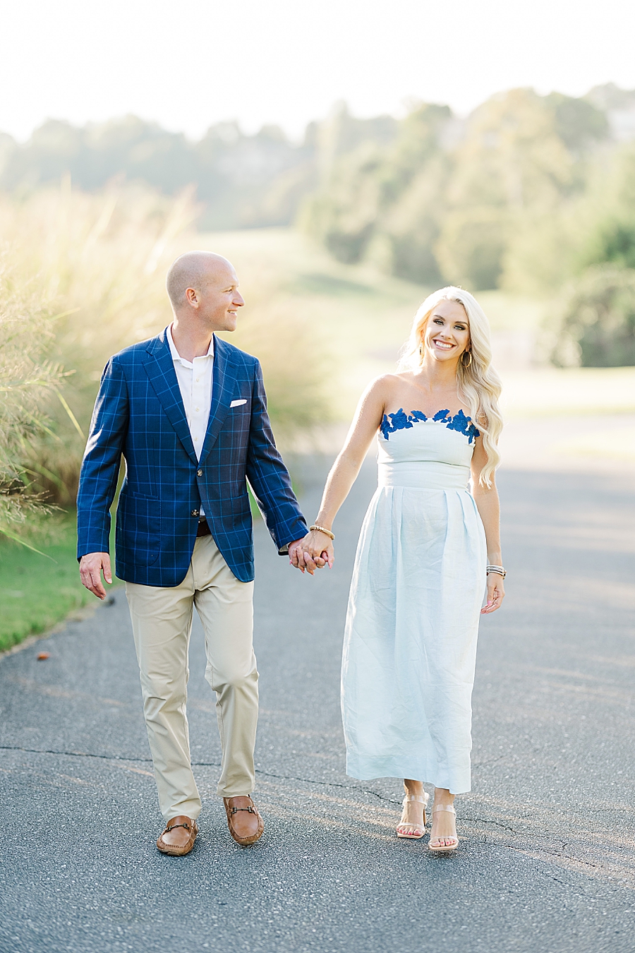 couple walking on golf course at johnson city engagement