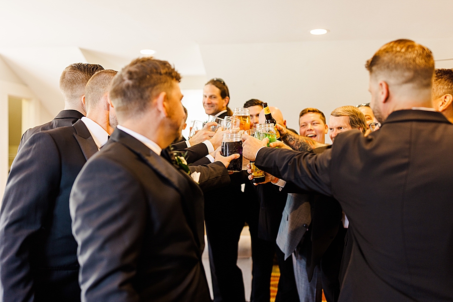 Groom and groomsmen raise glasses at Marblegate Wedding by Amanda May Photos
