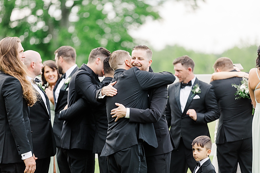 Groom hugging wedding party at wedding by Amanda May Photos