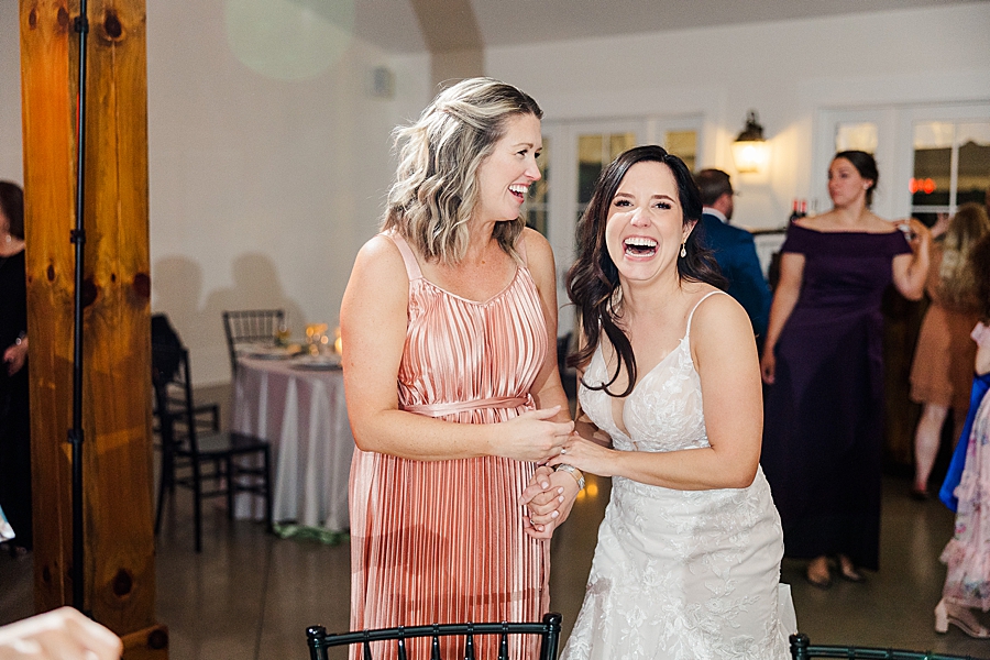 Bride laughing with guest at wedding by Amanda May Photos