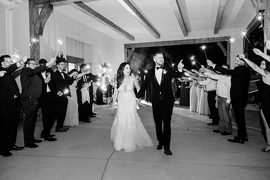 Bride and groom walking by sparklers for exit at wedding by Amanda May Photos
