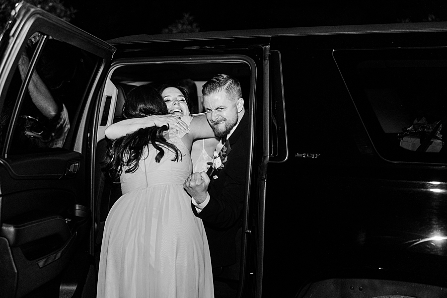 Bride and groom getting in car at wedding by Amanda May Photos
