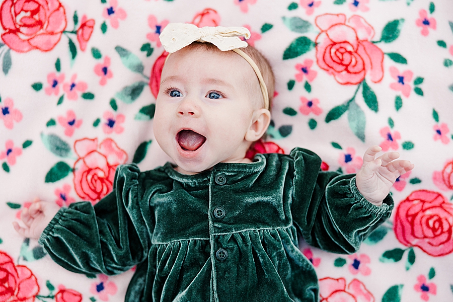 baby girl laying on rose blanket