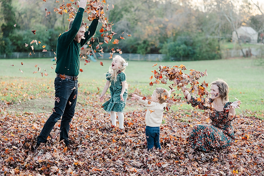 family playing in leaves