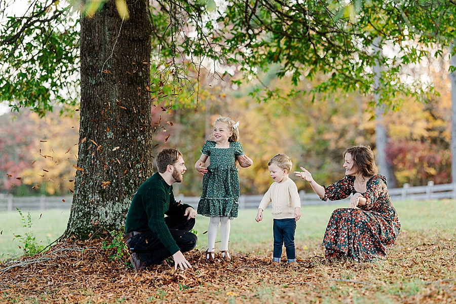 family playing in leaves