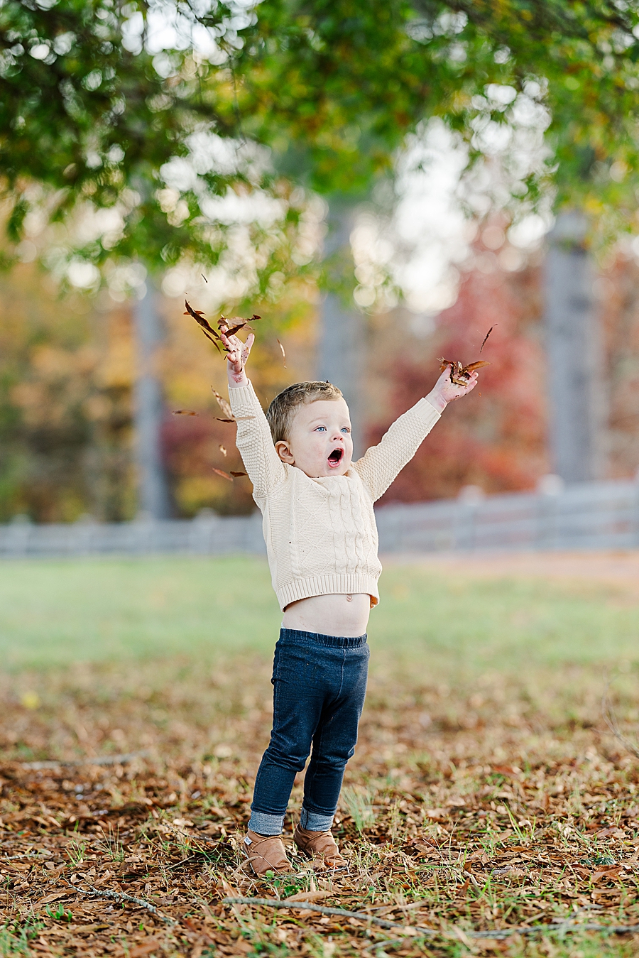 boy playing in leaves