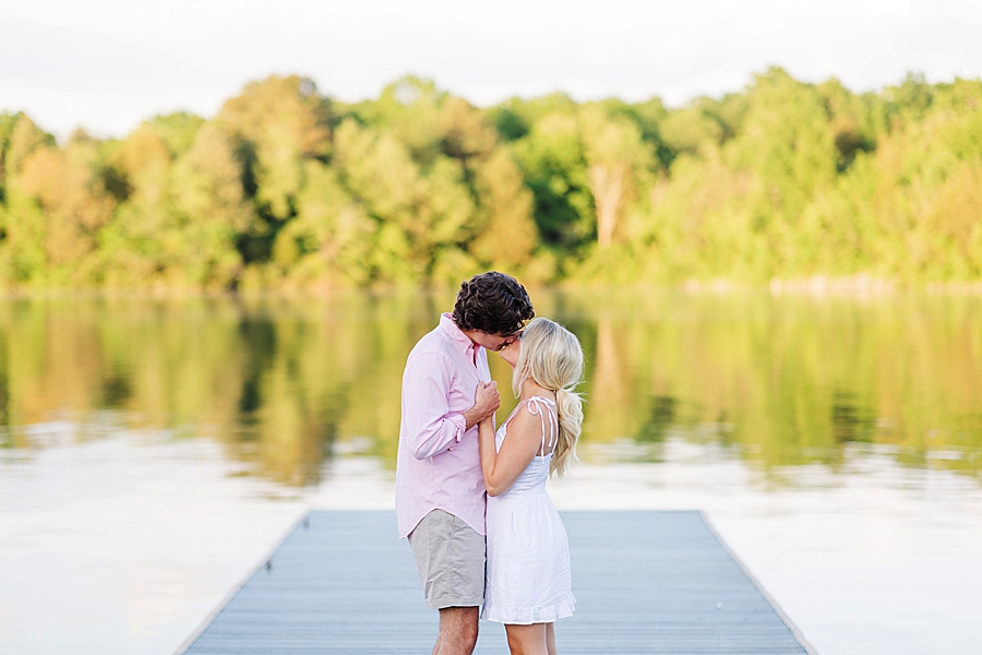 kissing on a dock at marblegate farm engagement