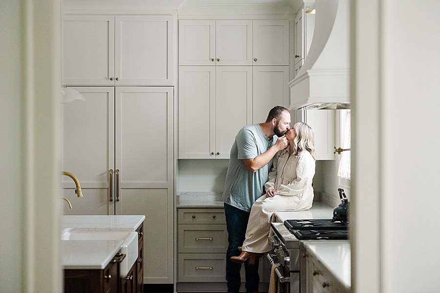 husband kissing wife in kitchen