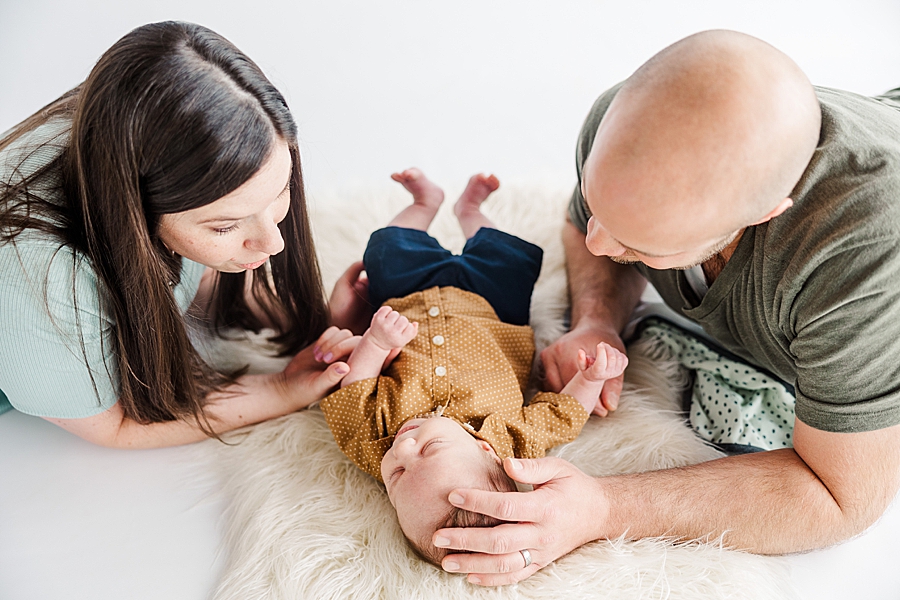 parents playing with baby on floor