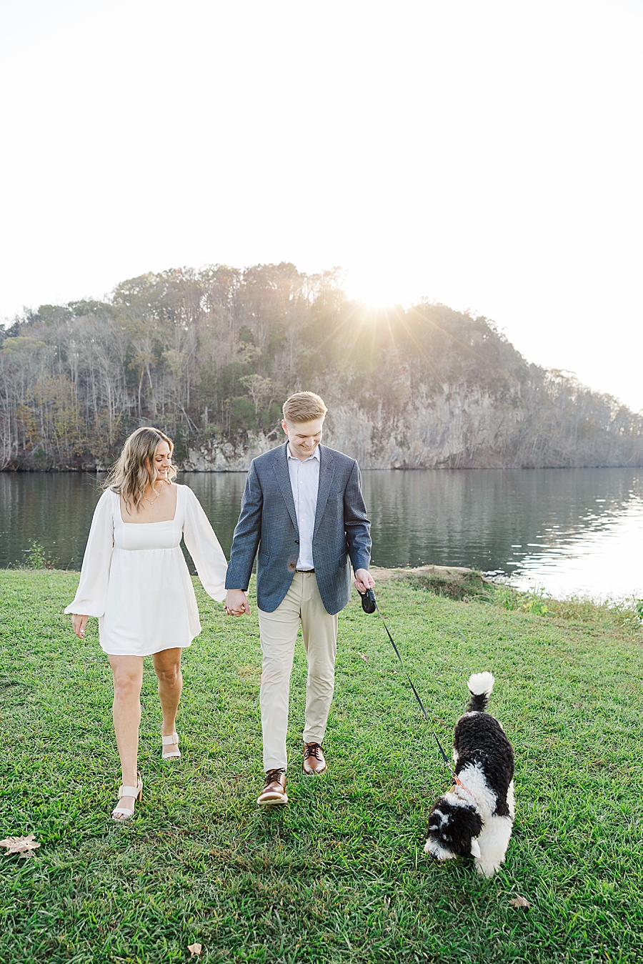 couple walking dog at park engagement