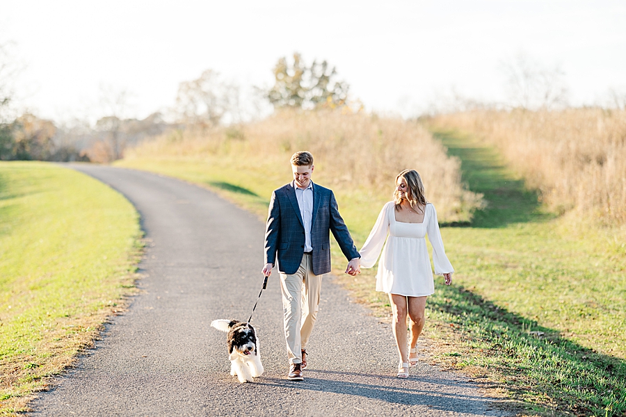 walking dog during golden hour at park engagement