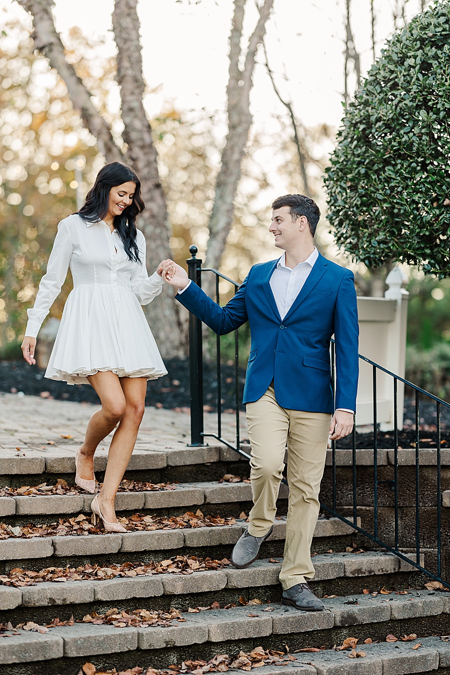 man helping woman walk down stairs