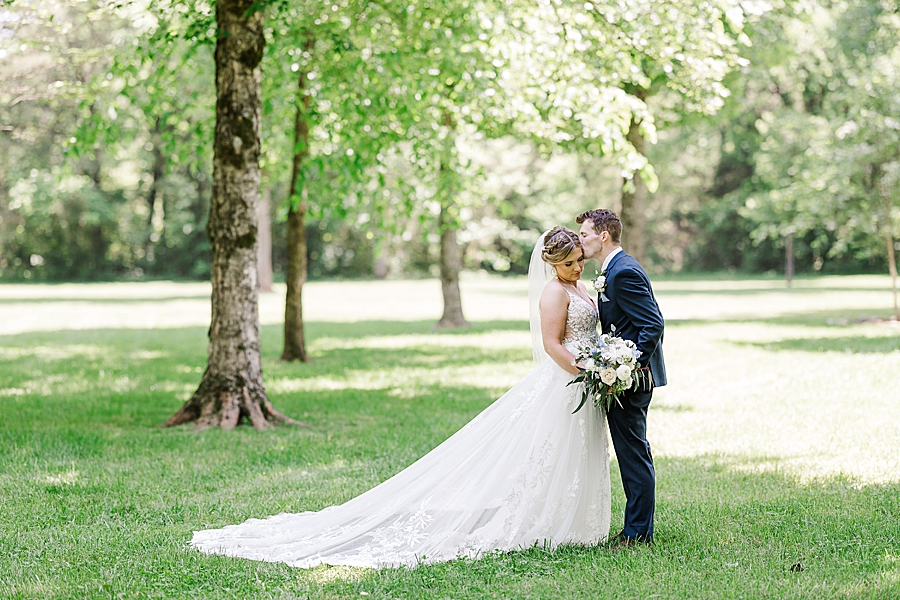 Groom kissing bride's forehead at Ramble Creek wedding by Amanda May Photos