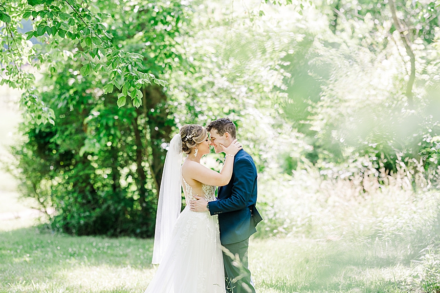 Bride and groom lean in for a kiss at Ramble Creek wedding by Amanda May Photos