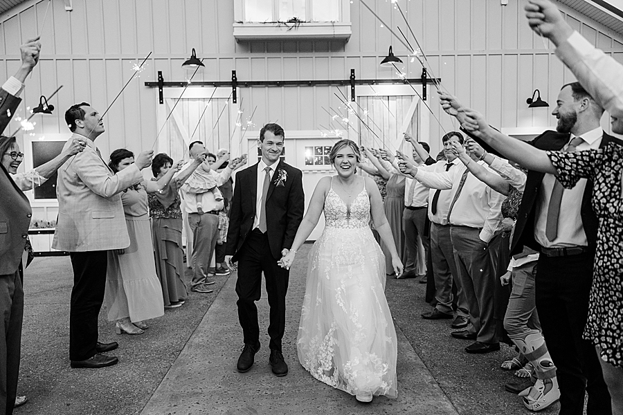 Bride and groom exit under sparklers at wedding by Amanda May Photos