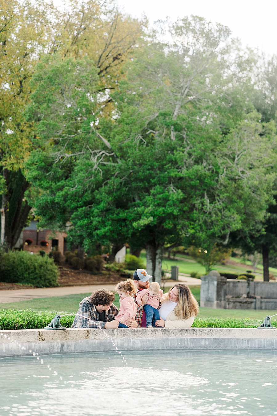 family playing in fountain