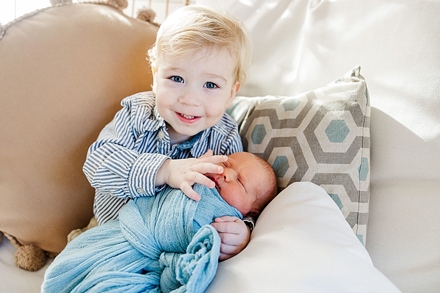 big brother holding little brother at sibling newborn session