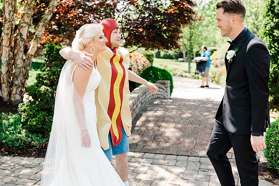 bride hugging man in hot dog costume