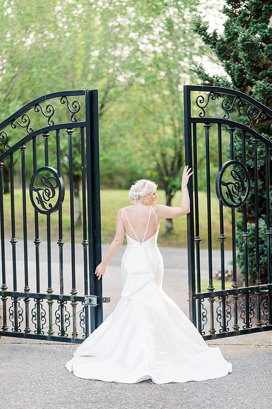 bride posing by black iron gate