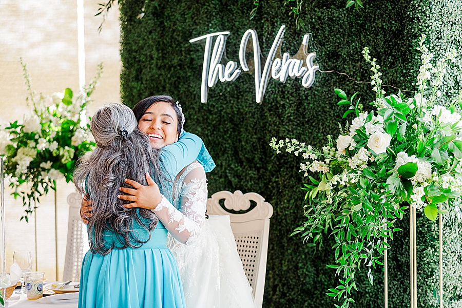 bride hugging guest in blue dress