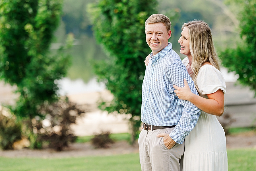 man with hands in pockets at sunset engagement session