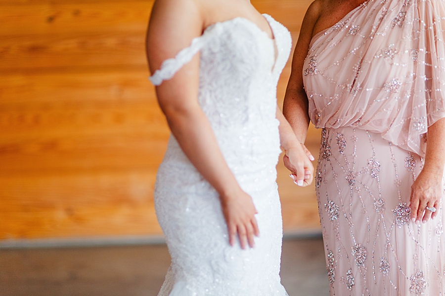 bride holding mother's hand at the carriage house