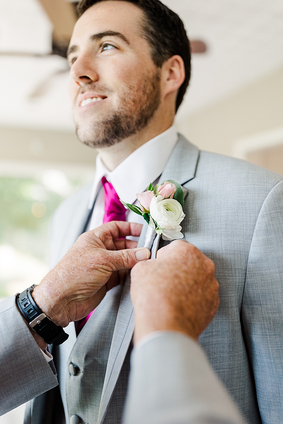 pinning on groom's boutonniere