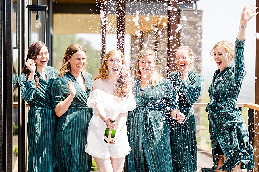 bride and bridesmaids popping champagne