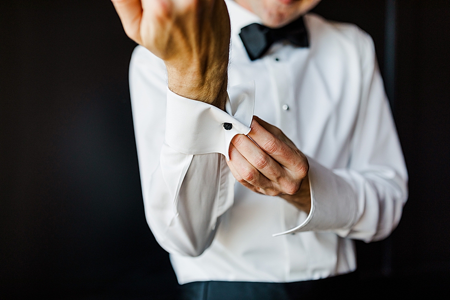 groom buttoning tuxedo sleeves