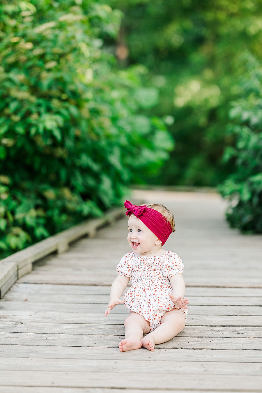 baby sitting on wooden bridge
