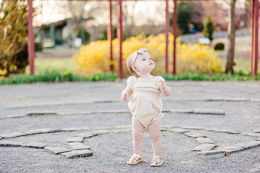 baby standing on gravel at ut gardens 1 year
