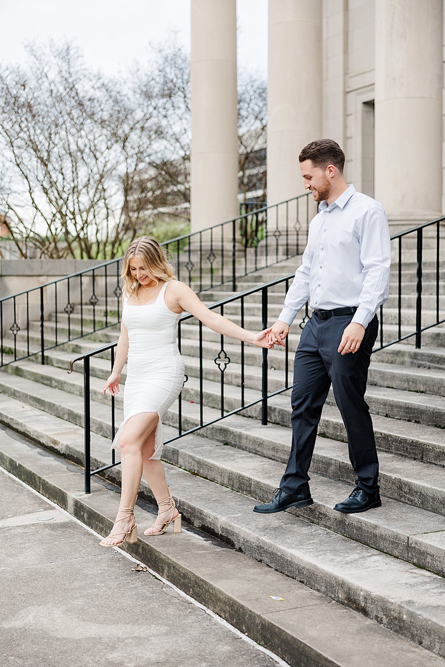 couple holding hands and walking down stairs