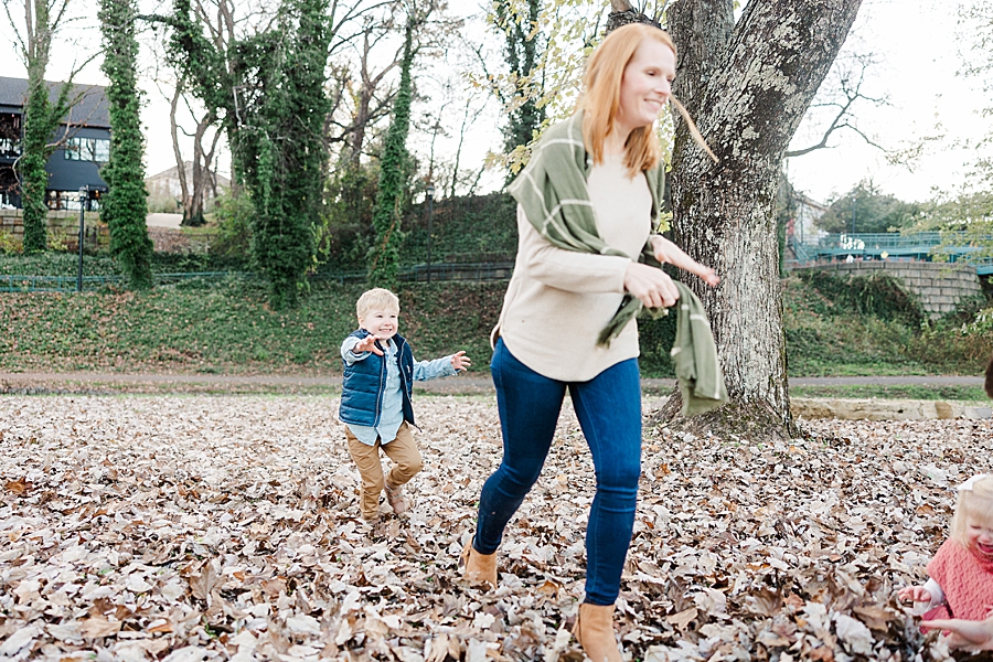 boy chasing mom with leaves