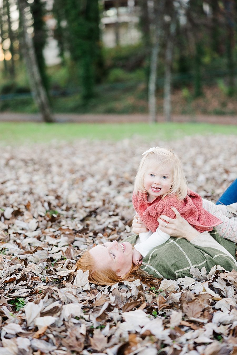 family laying in leaves
