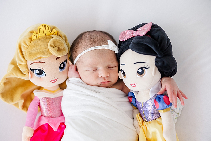 princess dolls with baby at white room newborn session