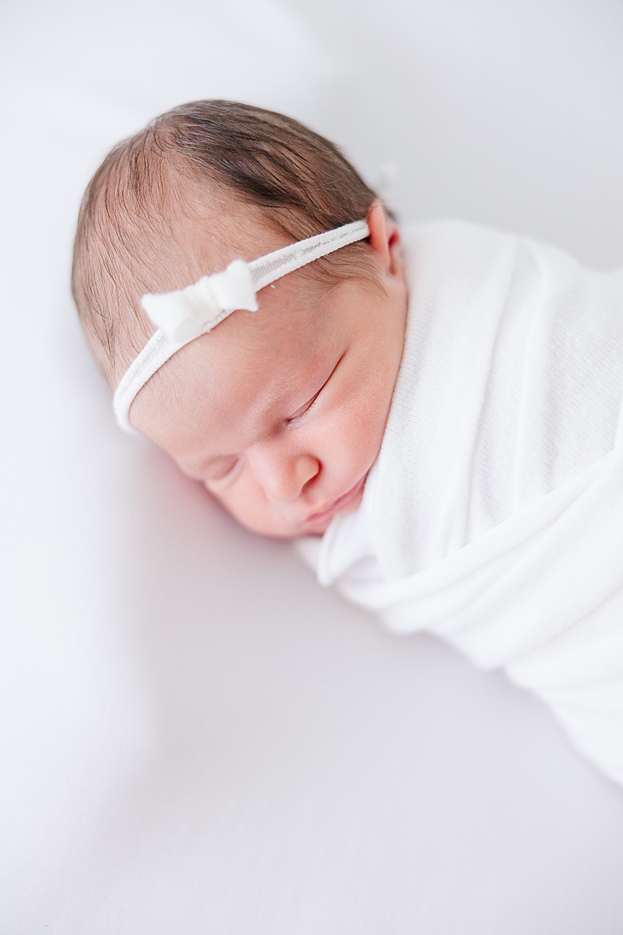 sleeping newborn in white headband