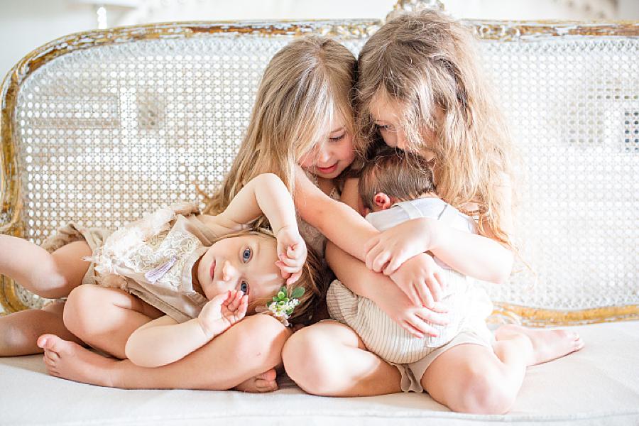 Sisters holding newborn brother