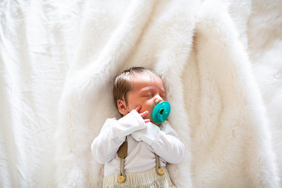 newborn with pacifier at lifestyle newborn session